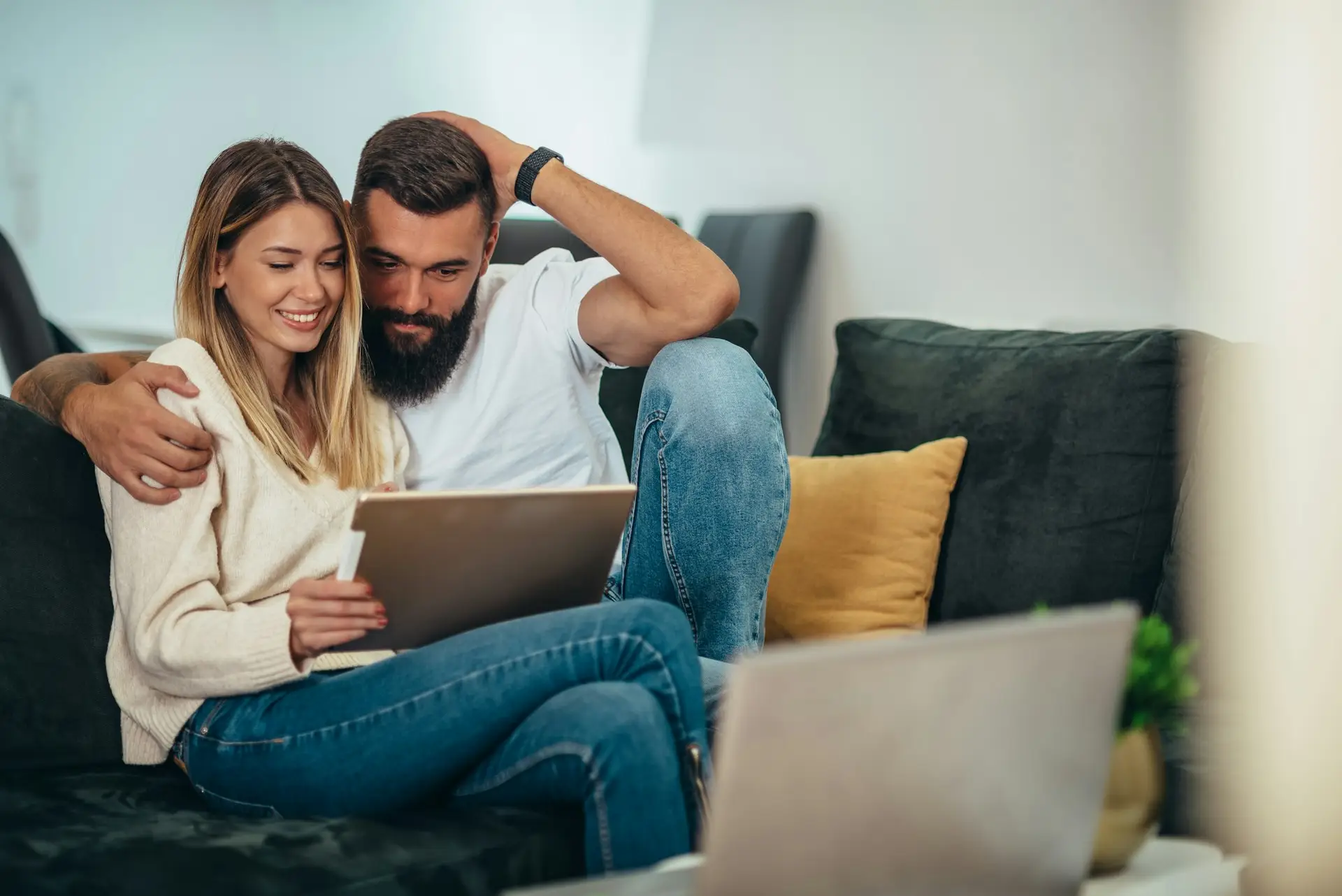 Couple using digital tablet for video call to review mortgage home loan with Irish Mortgage Corporation advisor.